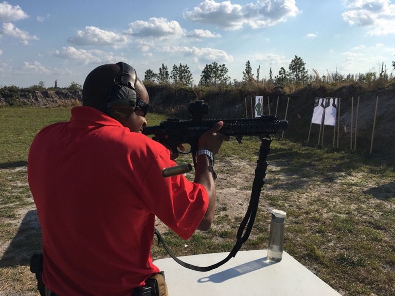 Instructor firing AR at outdoor range