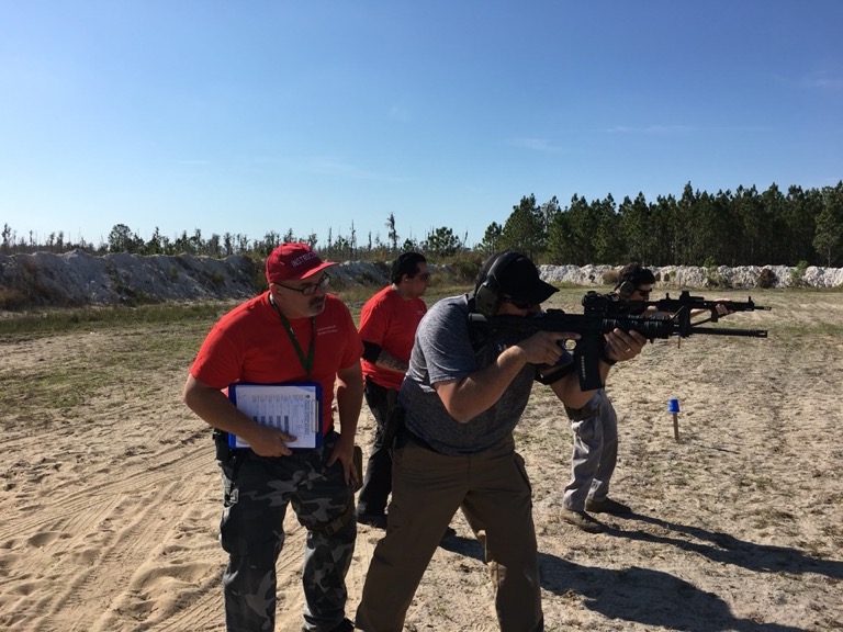 Josh and instructors supervising students at outdoor range